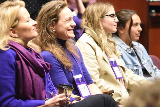 Photo of attentive audience members, listening to a presentation